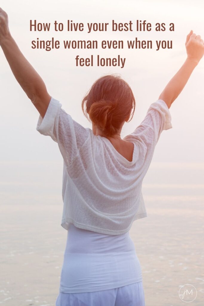 woman by the ocean stretching arms in the air