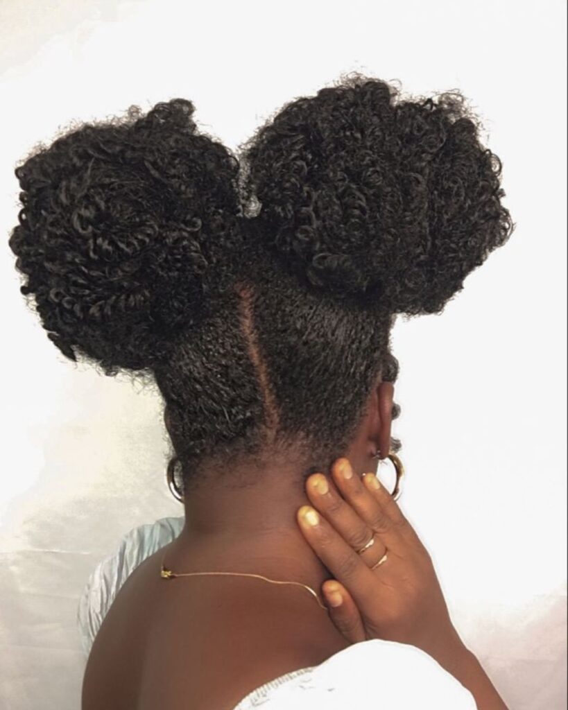 black woman with her hair in space buns looking away from the camera