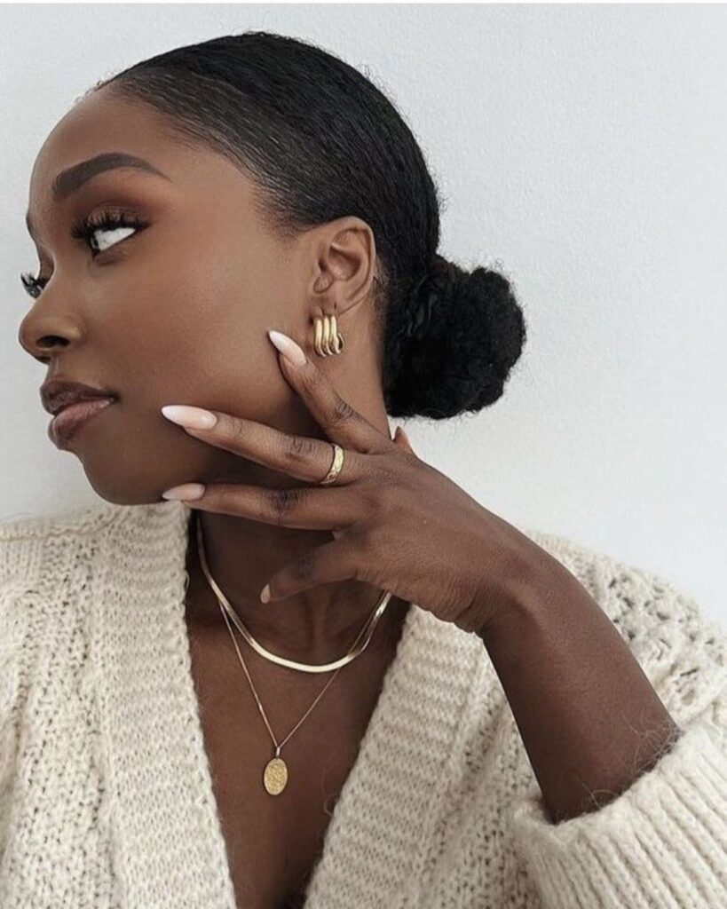 side angle of black woman with a very sleek low natural hair bun 