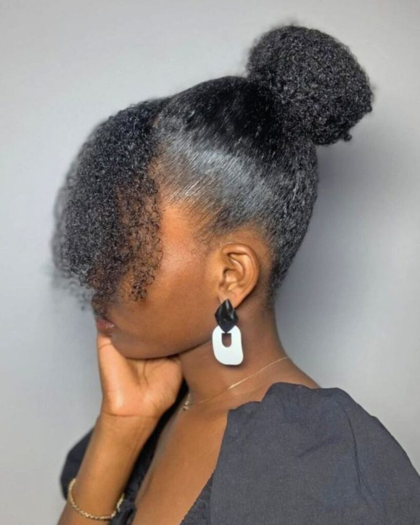 side angle of black woman with a sleek high bun 