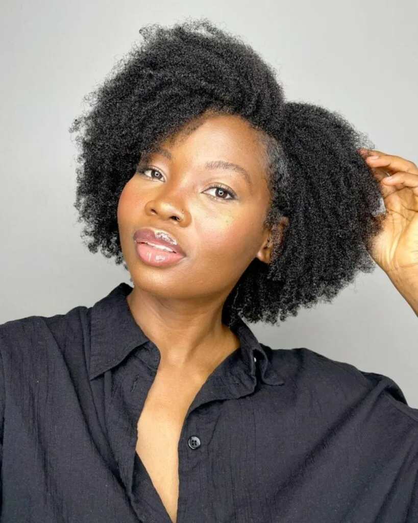 young black woman in black shirt with a defined wash and go hairstyle