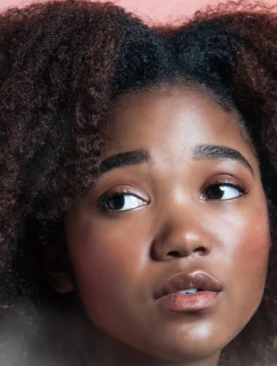 beautiful young black girl with big natural hair looking into the camera