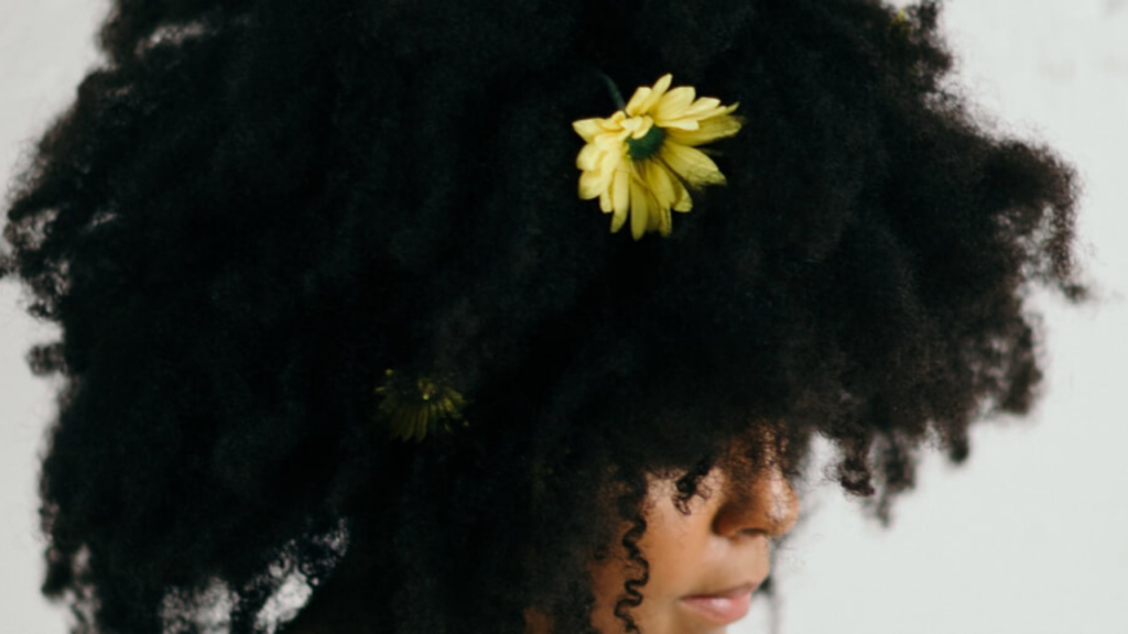 big afro hair with a sunflower in it