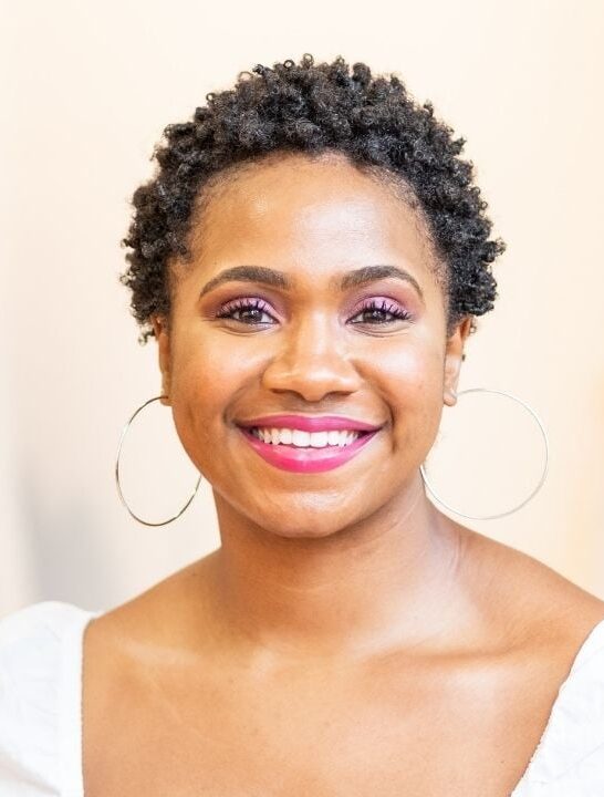 young black woman with short natural hair smiling into the camera