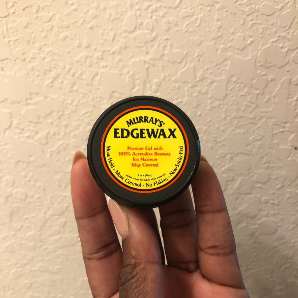 black hand holding  Murray&rsquo;s Edgewax 