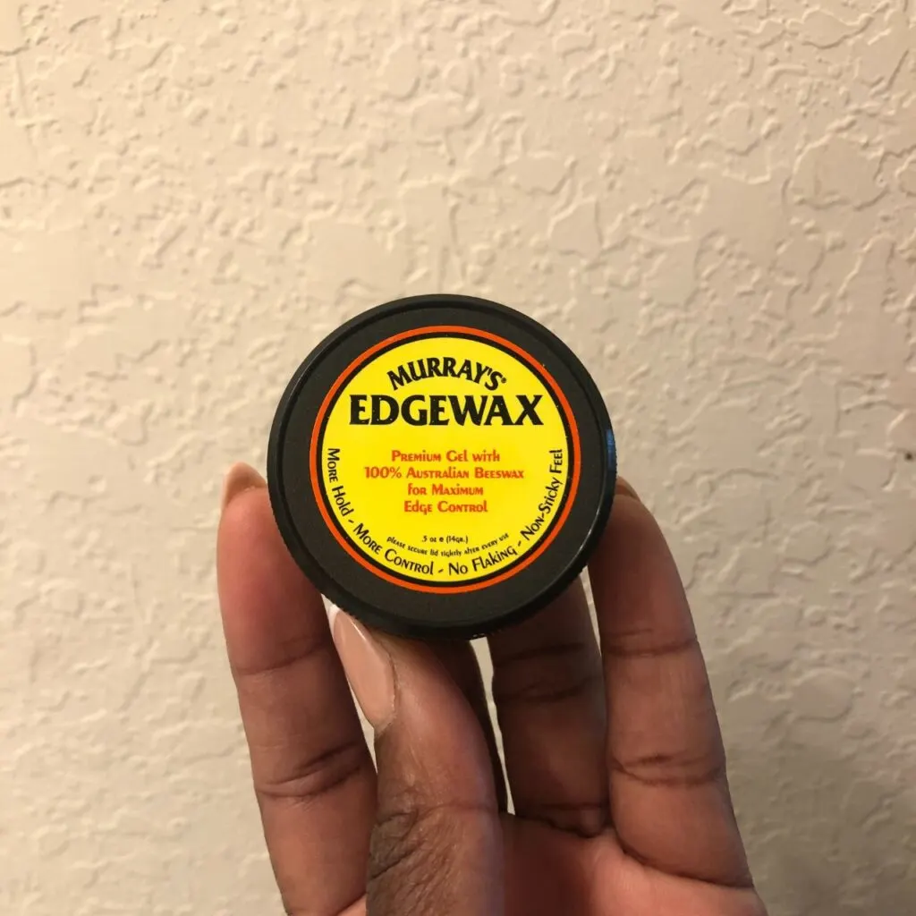 black hand holding  Murray&rsquo;s Edgewax 