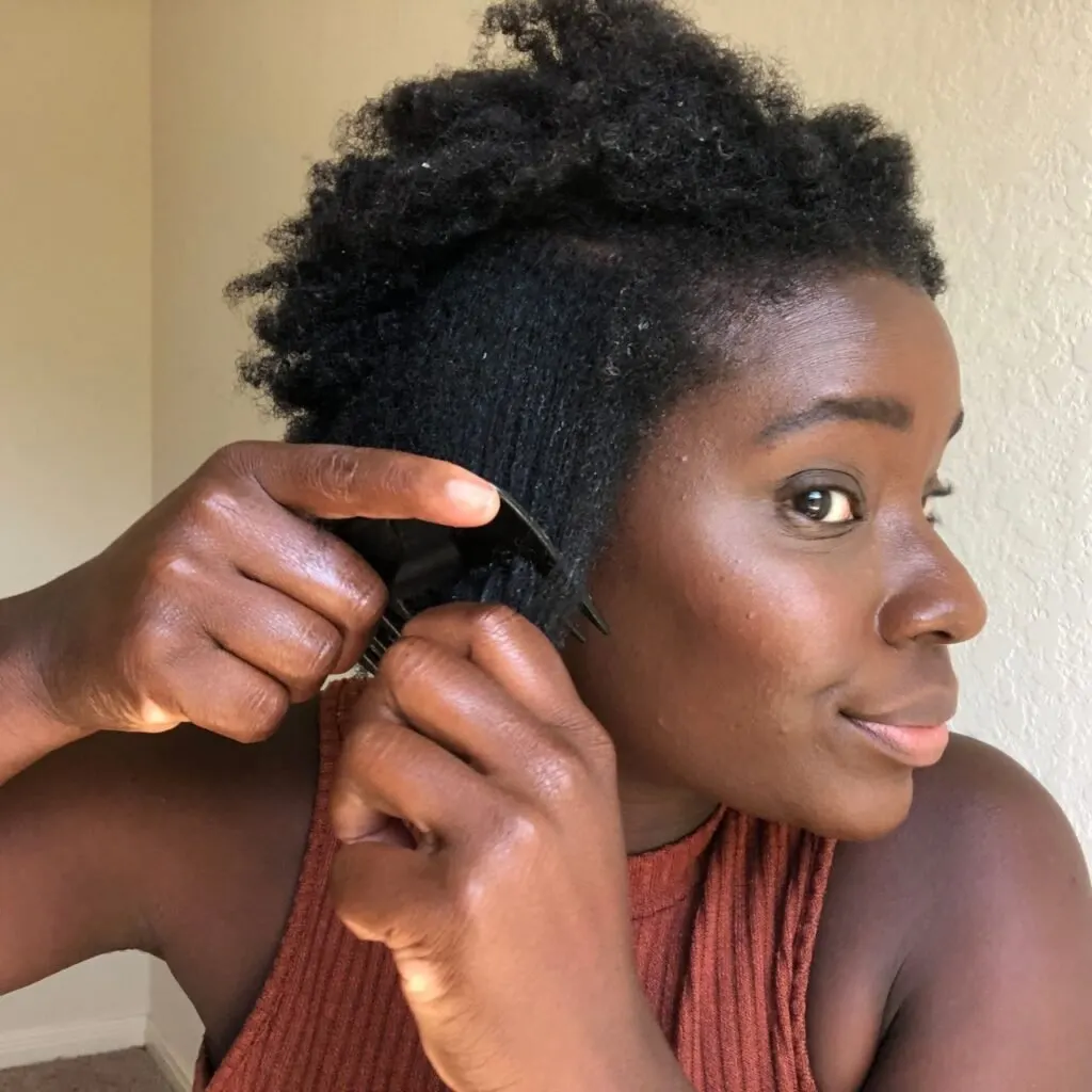 black woman with natural 4c hair, coming her wet hair