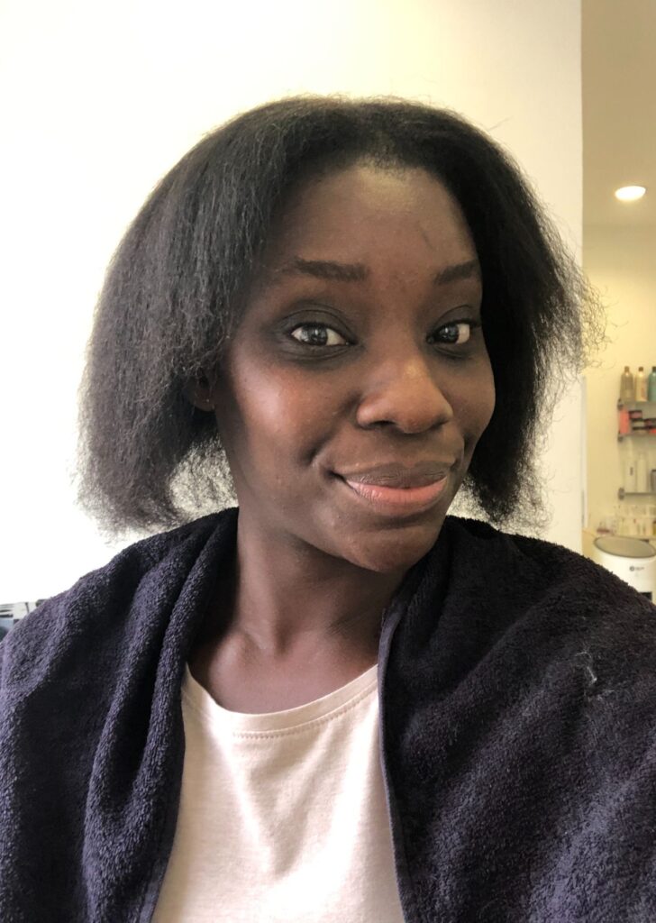 young black woman in a hair salon showing off blow blow dried hair