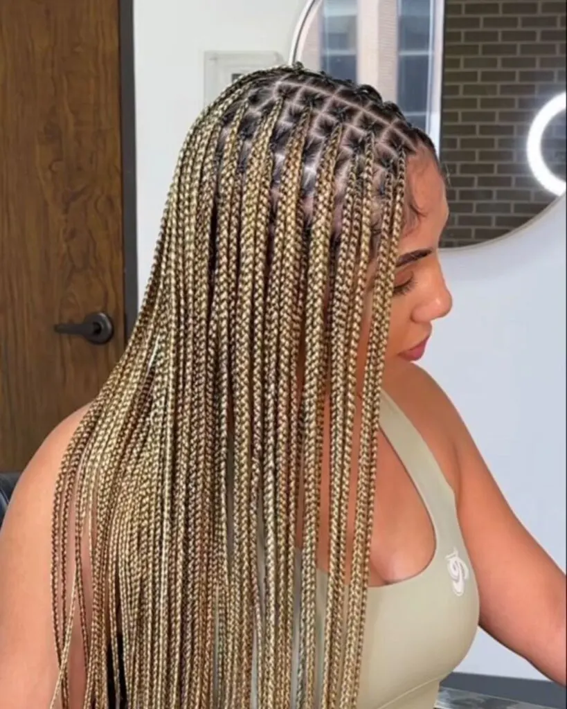 young woman showing side profile of blonde knotless braids