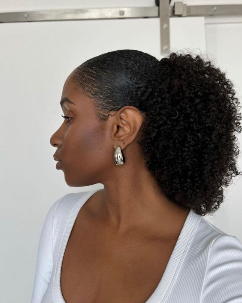 side profile of a young black woman wearing a low afro puff