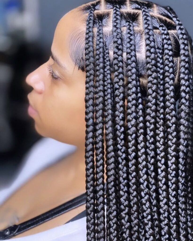 Women in Salon chair showing off her medium sized knotless braids