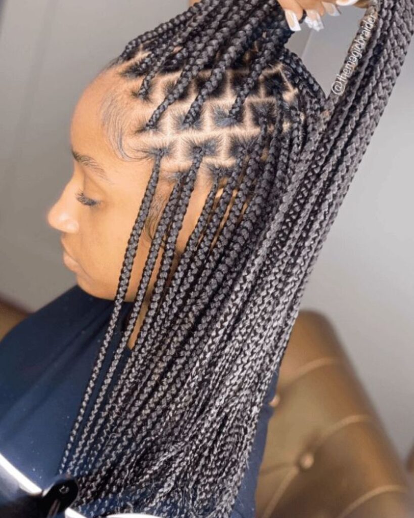 detailed view of a young black women with small Knotless Braids. Hair being parted by hairdresser