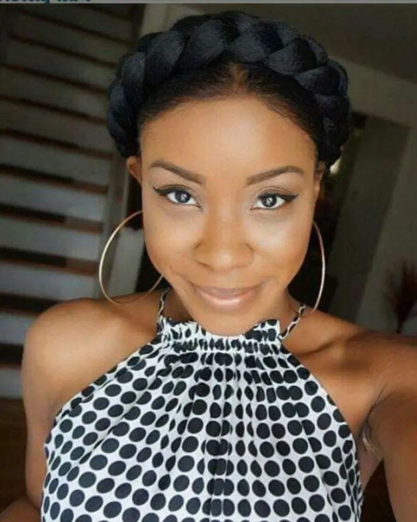 young black woman with a crown braid smiling into the camera