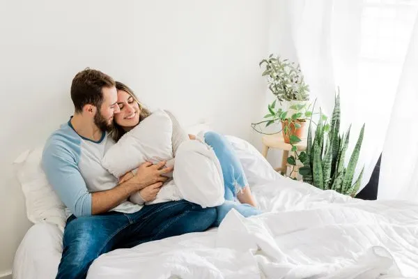 Young couple laying in bed cuddling