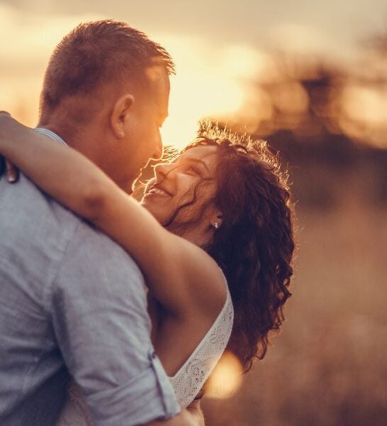 couple hugging in the middle of a field