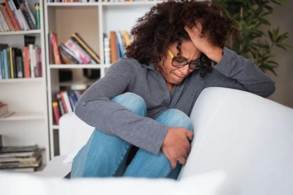 black woman sitting on the couch sad