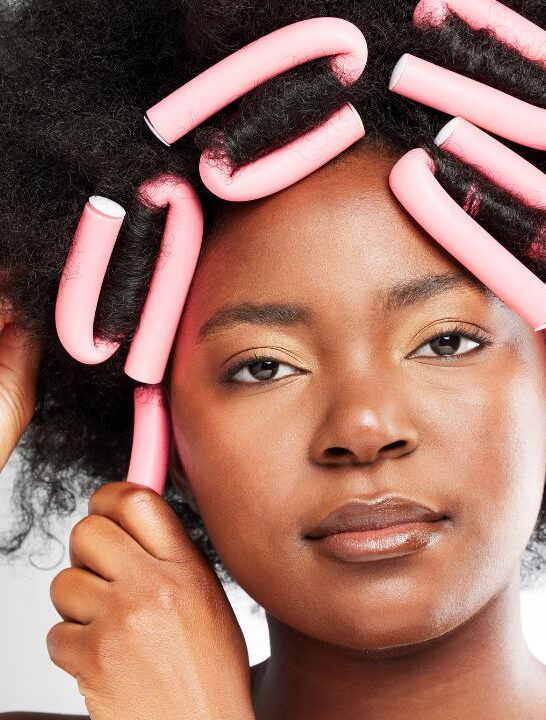 black woman putting her afro hair into flexi rods