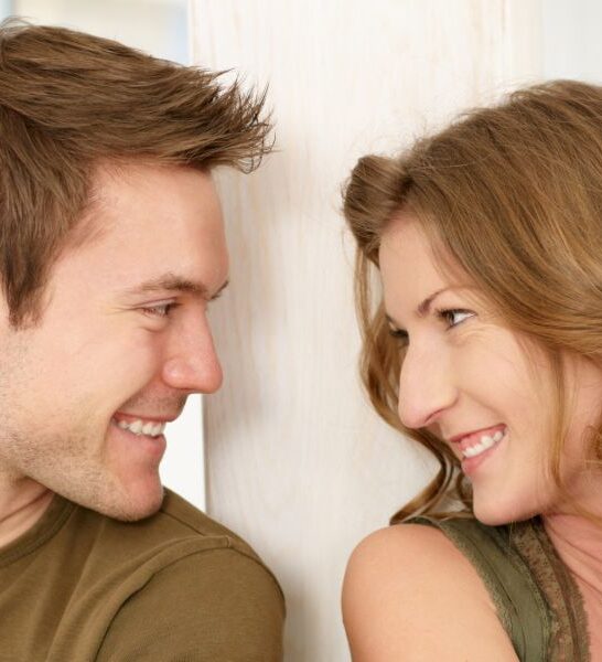 young couple looking into each other's eyes while smiling