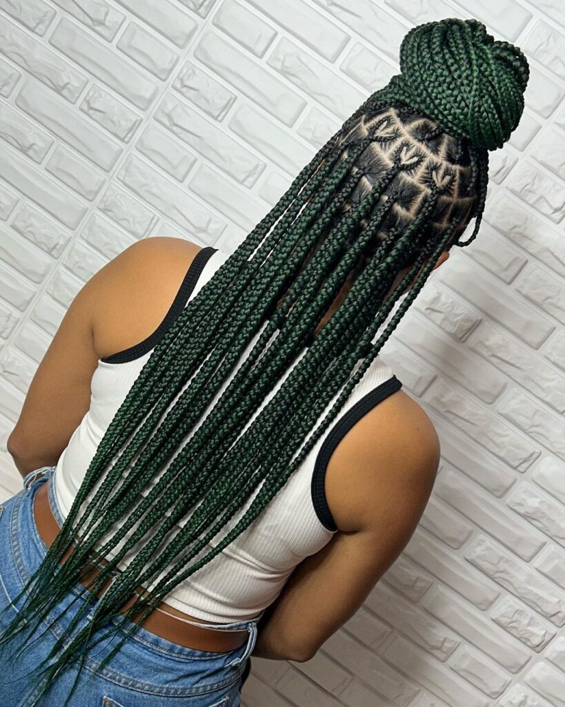 young black woman facing the wall while showing off her medium knotless braid hairstyle