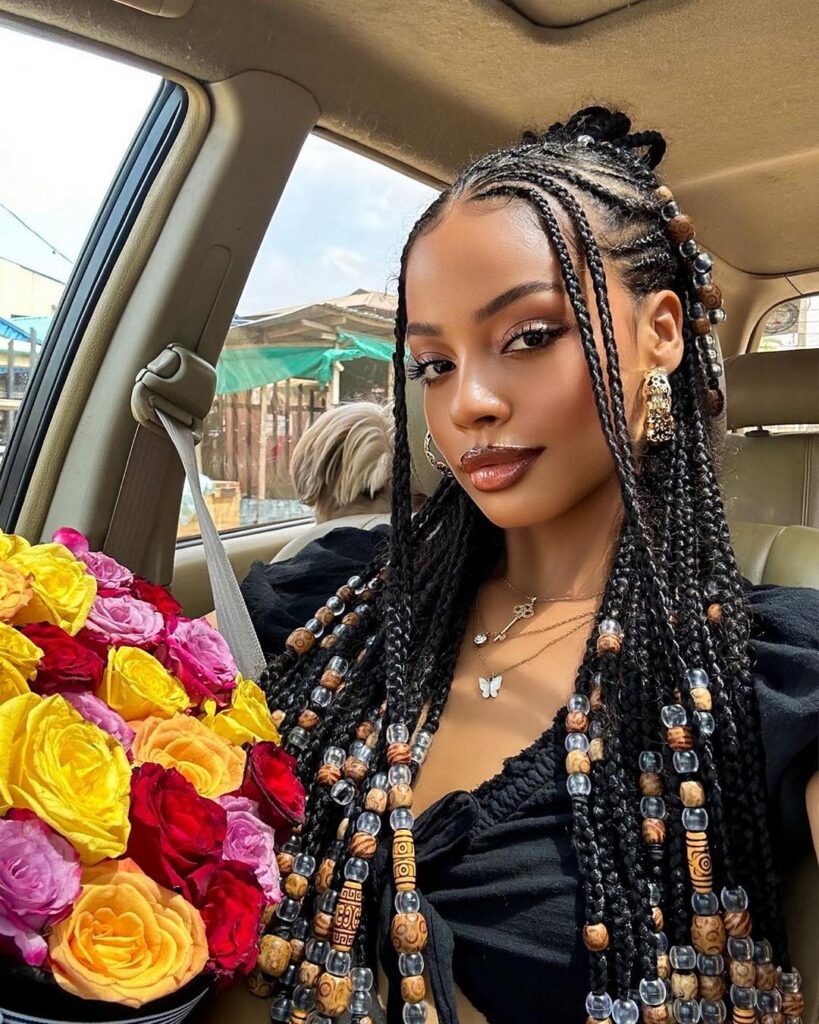 beautiful black woman holding flowers with tribal style cornrows with braids
