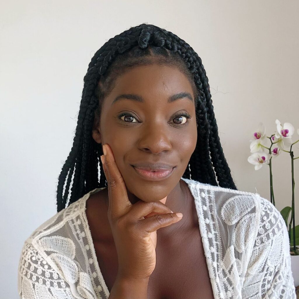 Beautiful young black woman with large box braids looking into the camera
